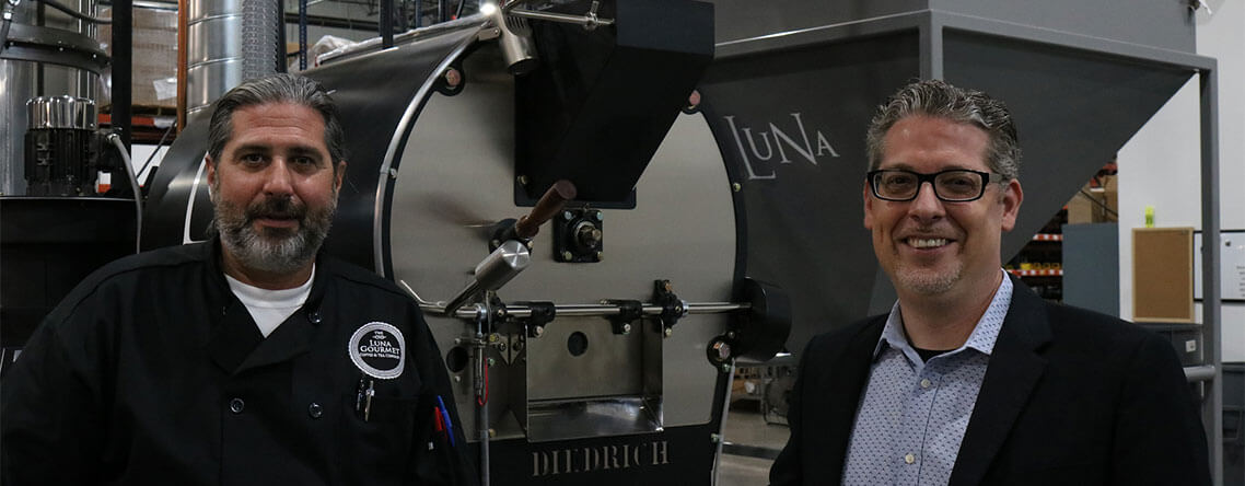 Doug and Jason in front of coffee machinery